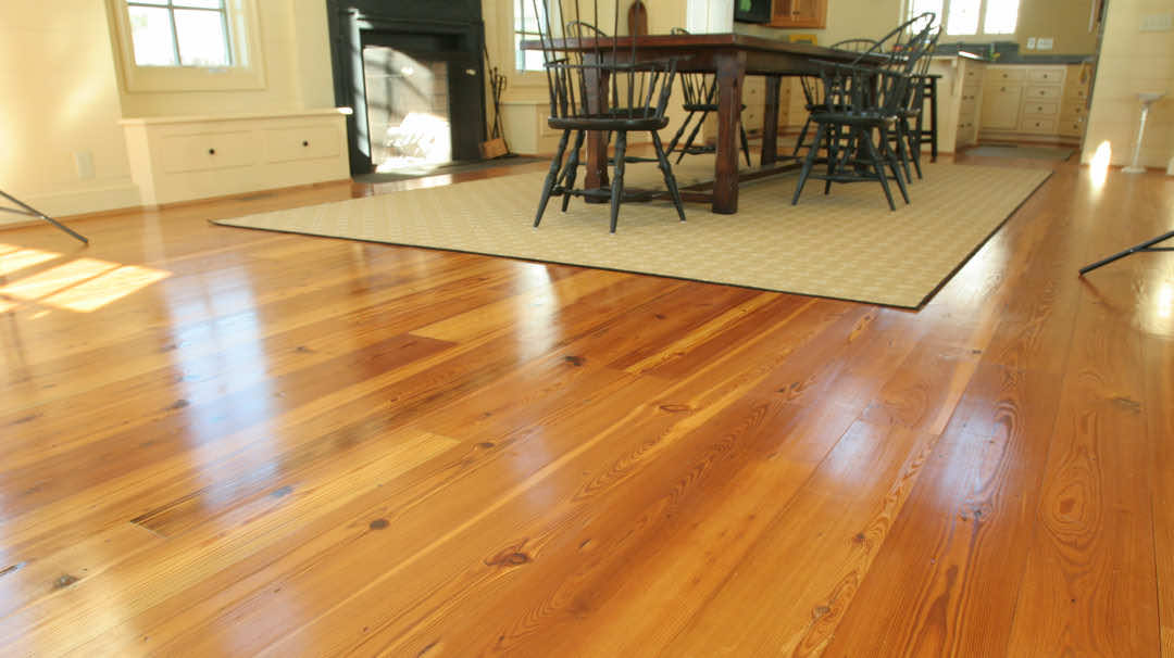 Rustic hardwood flooring in wide planks give an old world aesthetic to a dining room.